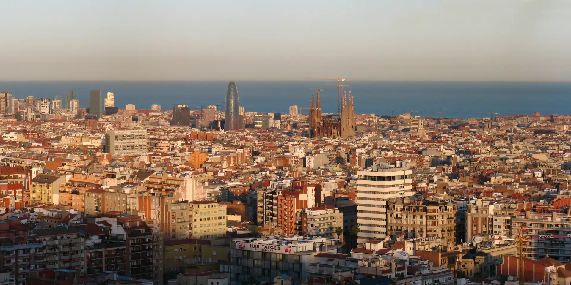 Barcelona al capvespre des del parc del Putxet, amb la Sagrada Família i la torre Glòries davant del mar
